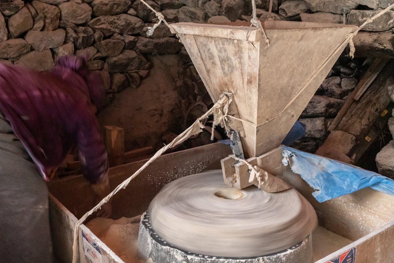 services-02 A traditional stone mill used for grinding grains in a rural Nepali village, showcasing local craftsmanship.